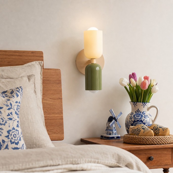 Wandlampen naast het bed verspreiden zacht warm licht rond het hoofdbord voor een rustige slaapkamer.