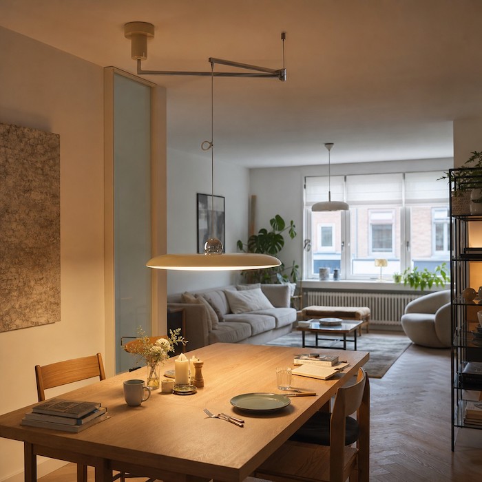 Minimal adjustable pendant light in a flexible modern dining space.