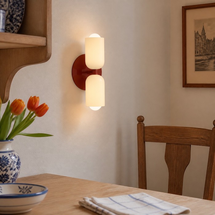 Dual-direction wall sconce adding depth behind a quiet sofa area.