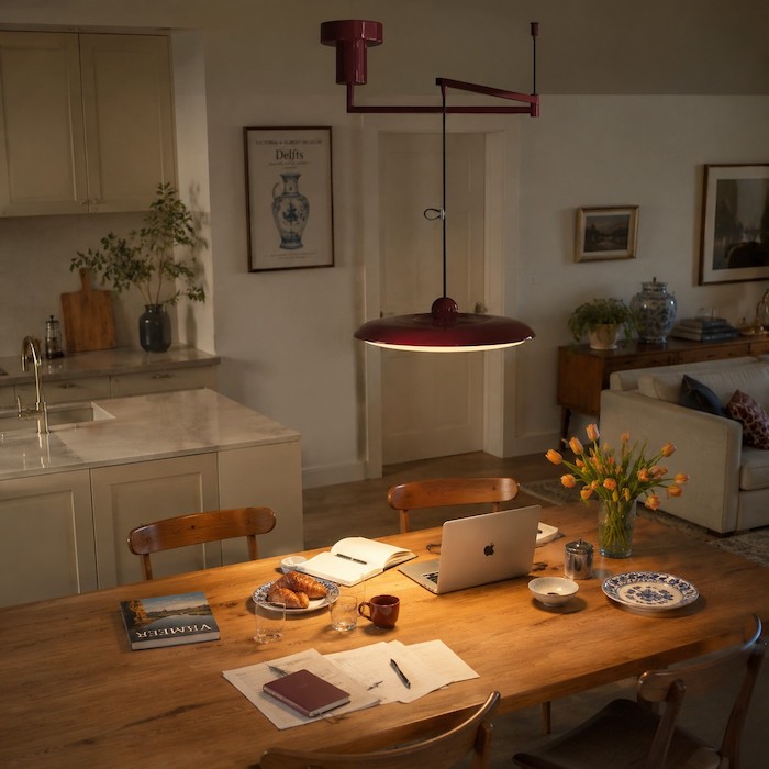 Focused pendant light marking a shared dining and work surface.