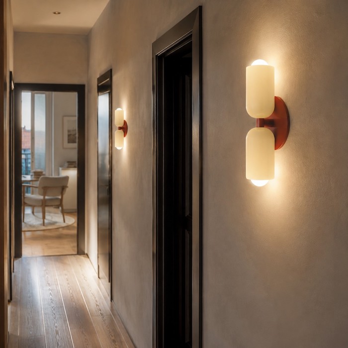 Compact wall sconce placed clear of doors and mirrors in a narrow passage.