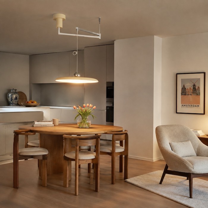Pendant-lit dining table with a separate reading light for another activity zone.