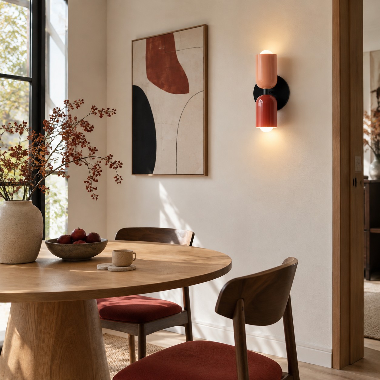 Colourful cylindrical wall sconce echoed by a small red accent in a modern dining room.