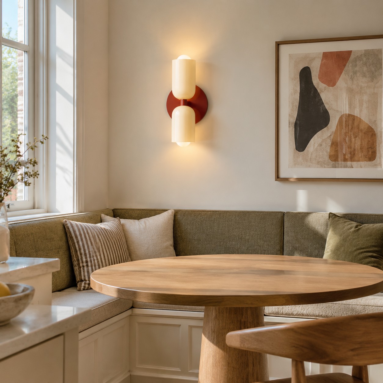 A wall sconce lights a compact dining nook while keeping the table clear.