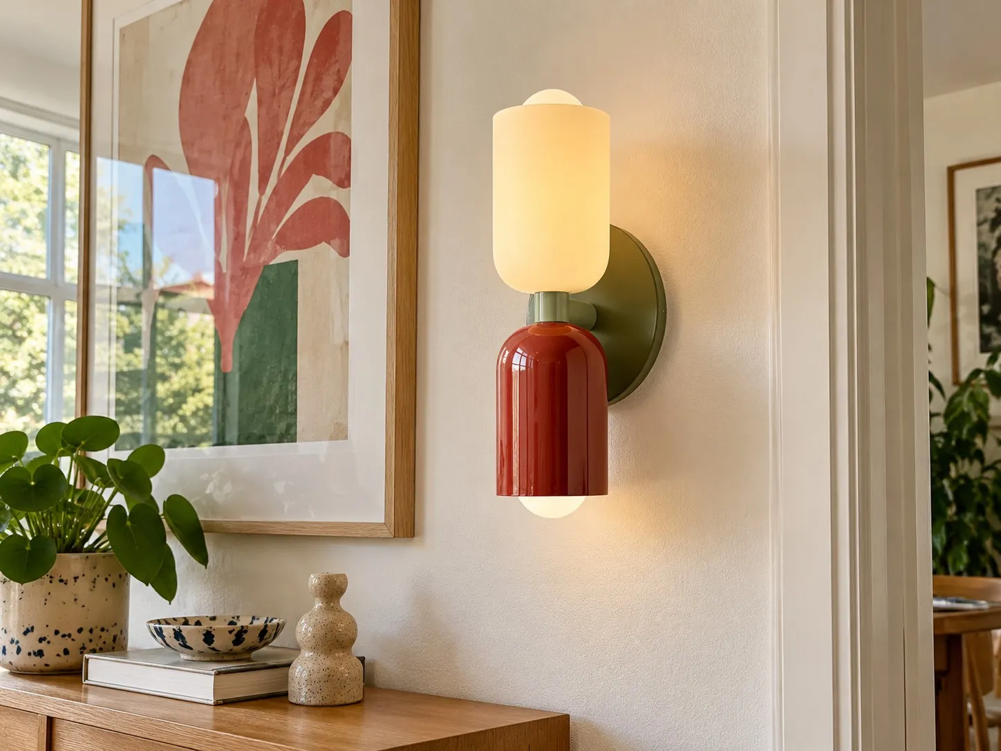 Close-up of a minimalist Nordic metal wall lamp installed beside framed art