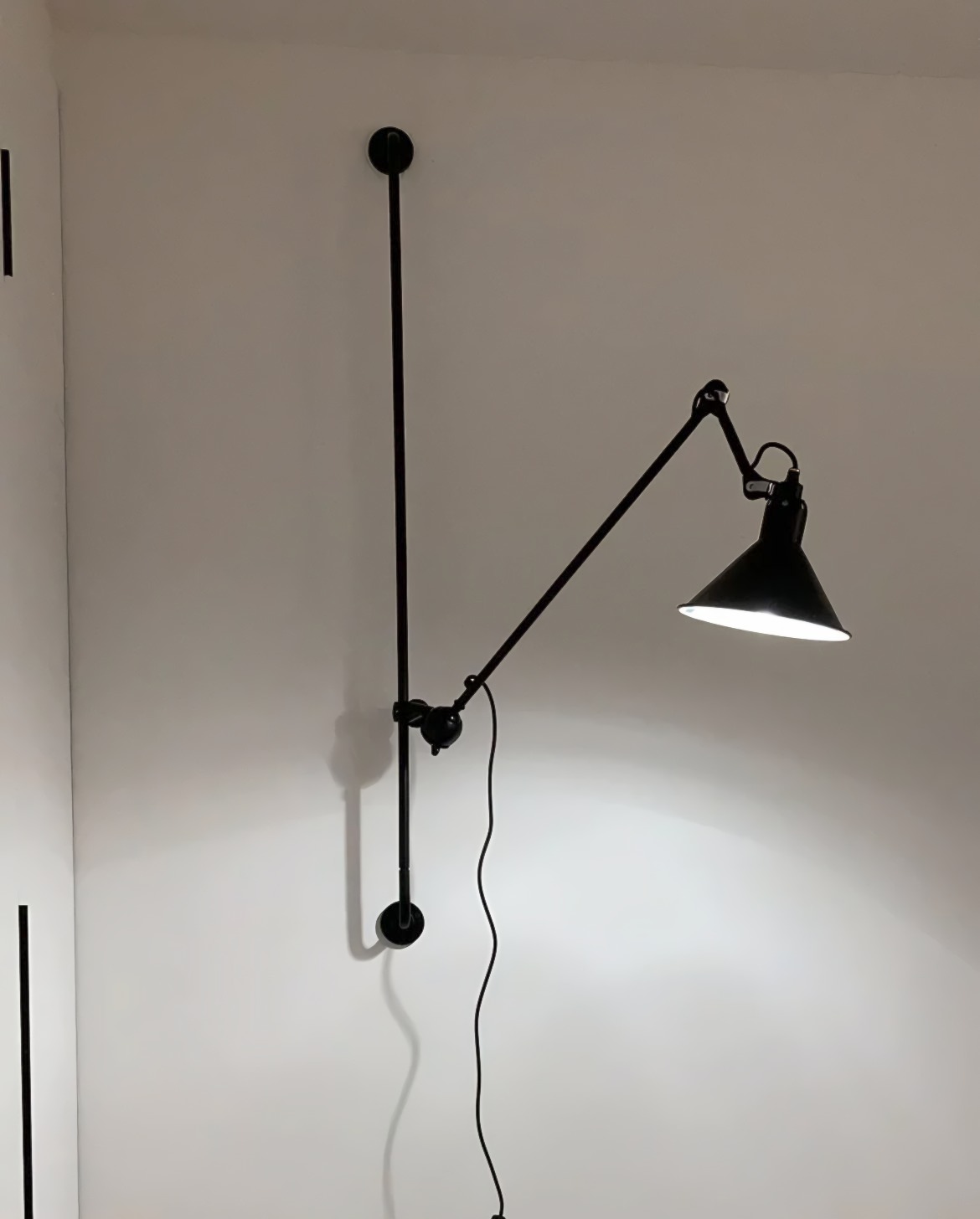 Zwarte wandlamp op witte muur