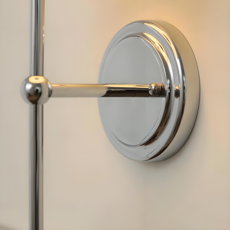 Detail van de chromen wandplaat en arm