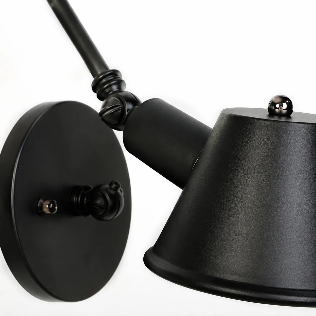 Close-up detail of the metal shade and joint on the retractable wall lamp